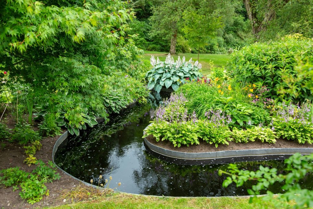 a garden with a pond surrounded by trees