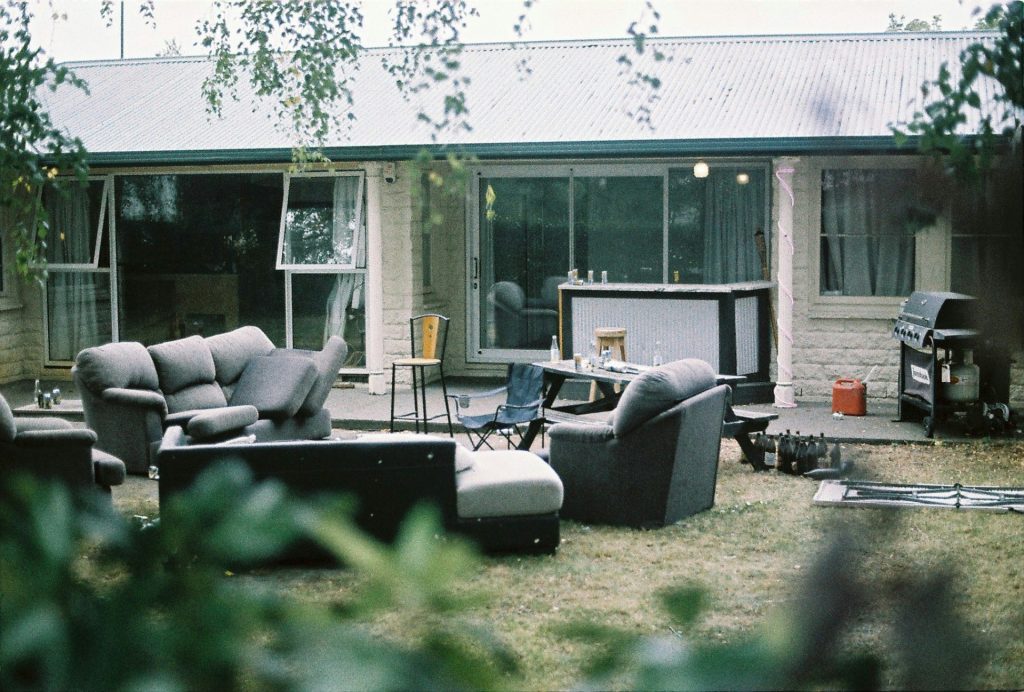 A group of couches and chairs outside of a house